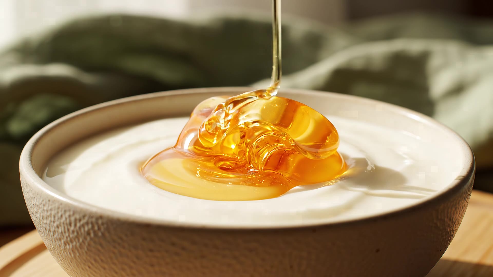 Golden honey folding into a bowl of thick yogurt